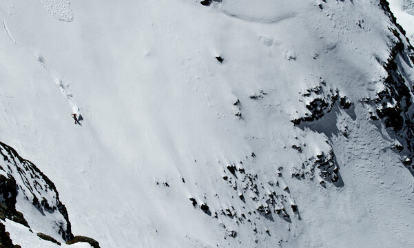 Top view of anonymous person skiing on snowy mountain at Swiss Alps on sunny day