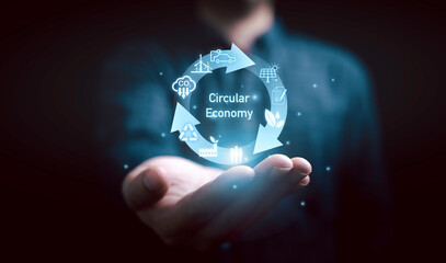 Businessman holding circle arrow with environmental icon for circular economy to sustainable...