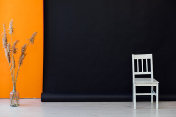 Interior of a black and orange room with colored chairs, armchairs