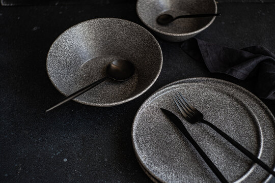 Modern dark tableware setup on a black background