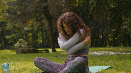 Sporty athletic Caucasian woman girl sport female on fitness mat in park outdoors yoga pilates...