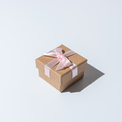 Gift box with strong shadows on white background. Creative Christmas or New Year concept.