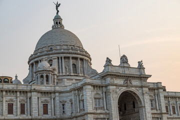 Obraz premium View of The famous Victoria Memorial with Garden, a large marble building in Central Kolkata, at the time of Sunrise.