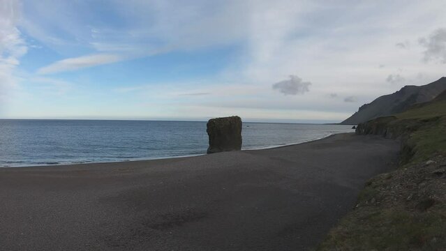 SLOW MOTION SHOT - Stapinn sea stack at Stapav&iacute;k is a unique part of the stunning coast south of &Aacute;lftafj&shy;&ouml;r&eth;ur in Iceland.