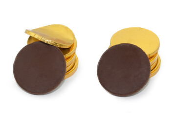 Stacks of chocolate coins in gold packaging with one dark chocolate coin unfolded in front view. Photo isolated on white background.