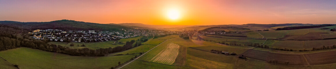 Panoramic aerial view of a sunset in winter over Taunusstein/Germany - obrazy, fototapety, plakaty