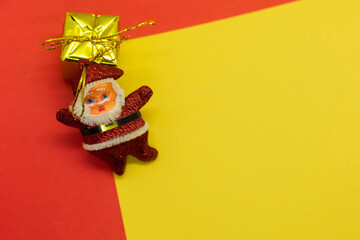 Santa Claus with gift box on red and yellow background. Christmas concept.