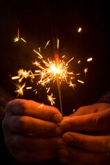Close up of people and sparkler light in dark black background and copy space. Holiday christmas...