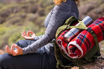  Zen and meditation activity in outdoor leisure lifestyle. Woman with backpack doing lotus position yoga. Concept of alternative healthy lifestyle and travel alone. Female people enjoying nature © simona