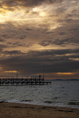 Fototapeta premium Sunset over a pier on the beach in Ravda, Bulgaria