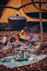 A pot on a fire against the background of a tent.
