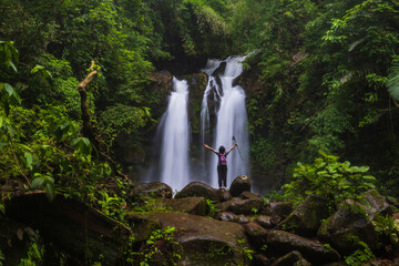 Young woman hiking on beautiful waterfall in Sapan village, Nan  province, ThaiLand.