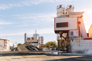 Yellow excavator truck transportation sand on industrial cement factory. Concrete plant industry...