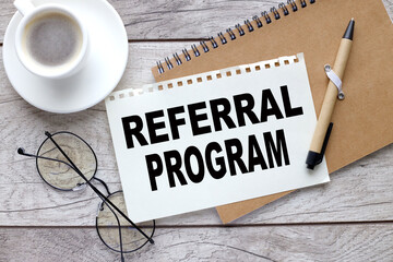 REFERRAL PROGRAM notepad with pen and sheet of paper with text