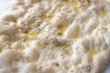 Typical Italian Focaccia Bread dough with oil and rosemary without baking