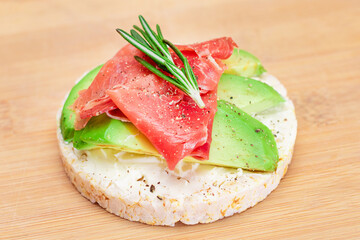 Rice Cake Sandwich with Fresh Avocado, Jamon and Rosemary on Bamboo Cutting Board. Easy Breakfast....