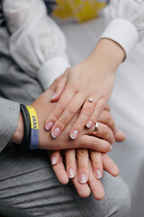Closeup view to Ukrainian newlyweds holding each other hands.