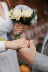 Obraz na płótnie Canvas Closeup view to newlyweds holding each other hands.