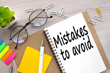 Mistakes To Avoid open notepad with text. bright stickers point to text