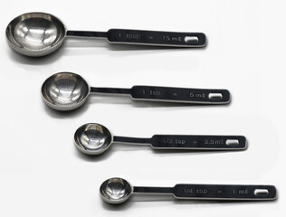 A set of metal measuring spoons for cookery