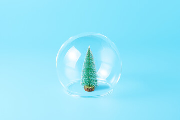 Christmas tree under the glass dome on blue background. Minimal New Year wallpaper. Holiday...