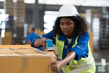 Female warehouse worker packing cardboard box of goods with scotch tape in the storage warehouse