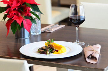 Close up Gourmet tasty roast beef steak with mashed potatoes and other vegetables on a white plate, served food in a restaurant, wine