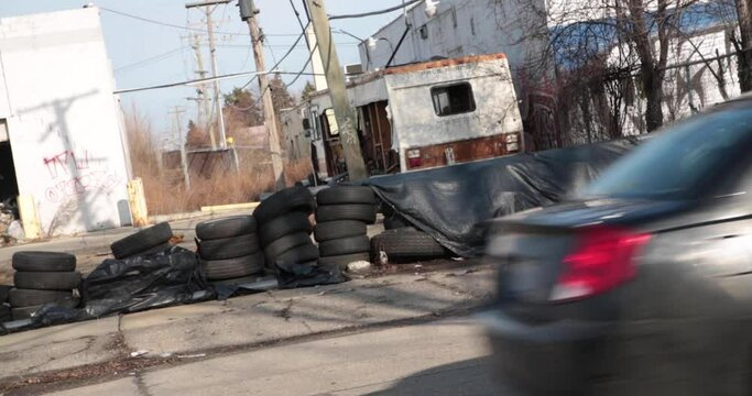 Urban Illegal dumping of tires and vehicles at an abandoned building