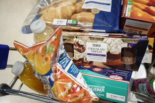 Tesco Chocolate Trifles in a grocery cart with many different groceries. 