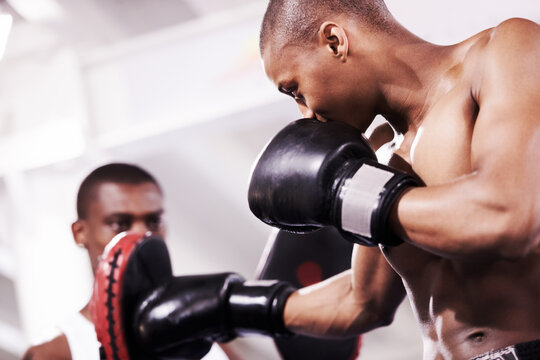 Black man, boxing and personal trainer in self defense or ring fight at gym workout, exercise or indoor training together. African male person, boxer or sparing partner preparing sports competition