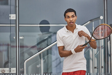 athletic african american sportsman playing squash inside of court, challenge and motivation
