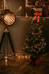 Modern New Year's decor for the living room and bedroom. Christmas tree, decorated with New Year's toys, stands near the fireplace