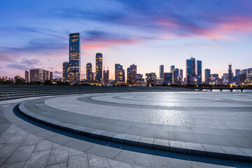 Empty square floor and city skyline with modern commercial buildings in Shenzhen at dusk, Guangdong...