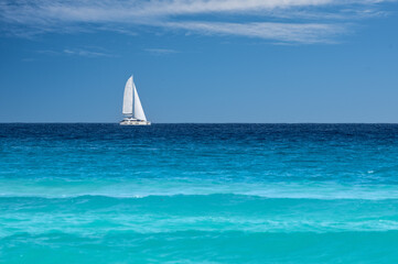 sailboat near Cancun with various blue colors 
