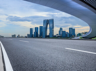Asphalt road and city skyline with modern buildings in Suzhou, Jiangsu Province, China.