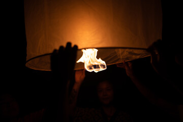CHIANG MAI, THAILAND - SEPTEMBER 14, 2023: Man and woman holding paper lantern during Yi Peng festival, Chiang Mai, Thailand