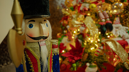 Fototapeta na wymiar Christmas tree full of decorations with Nutcracker posing.