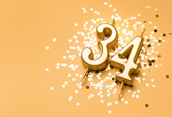 34 years birthday celebration festive background made with golden candle in the form of number...