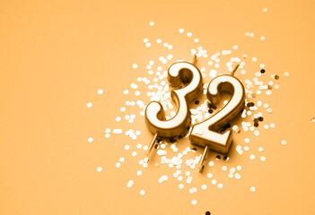 32 years birthday celebration festive background made with golden candle in the form of number...