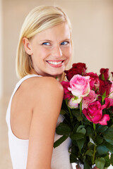 Woman, rose bouquet and smile with face, beauty and arrangement with studio background, happy and gift. Look, female model and flowers for love, present and valentines day with romantic gesture © Cameron M/peopleimages.com