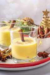 Rompope, Mexican eggnog vegan cocktail. Christmas vegetarian non-dairy drink, Egg Liqueur with cinnamon and spices, on Christmas and New year festive holiday decorated background