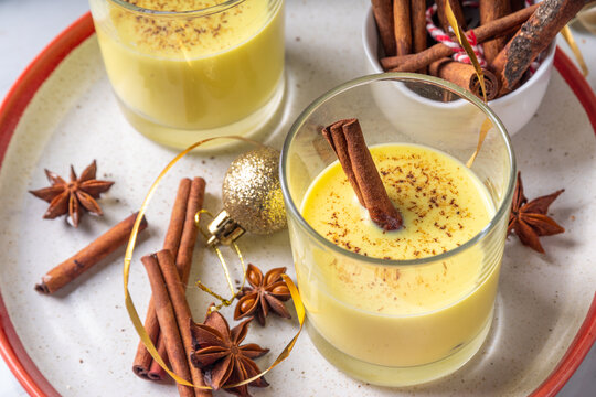 Rompope, Mexican eggnog vegan cocktail. Christmas vegetarian non-dairy drink, Egg Liqueur with cinnamon and spices, on Christmas and New year festive holiday decorated background