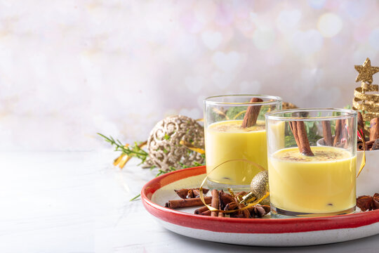 Rompope, Mexican eggnog vegan cocktail. Christmas vegetarian non-dairy drink, Egg Liqueur with cinnamon and spices, on Christmas and New year festive holiday decorated background