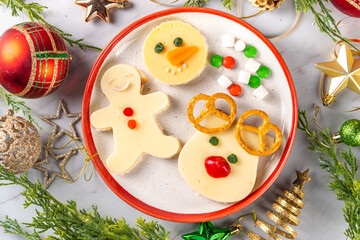 Christmas breakfast cheese sandwiches in form of xmas holiday festive symbols - gingerbread man, reindeer, snowman, top view copy space. Funny kids New Year and Christmas snack, lunch idea