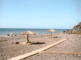 beach with umbrella and wooden walk