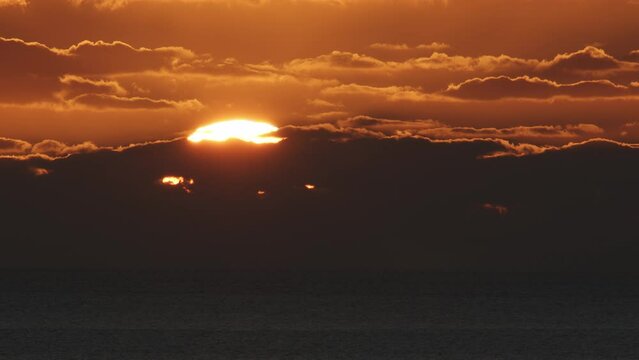 Beautiful evening sunset with big Sun and clouds in the Atlantic Ocean at Portugal coast.