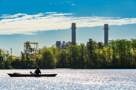 A kayaker passes by a natural gas fired power plant along the Cape Fear River near Wilmington, North Carolina