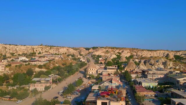 Elevate your visual experience with this captivating aerial stock photo of Goreme, Cappadocia, Turkey. The ancient city unfolds below, revealing its extraordinary charm with houses gracefully carved