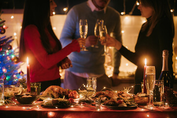 Beautiful decorated Christmas table with variety of festive dishes and people drinking champagne