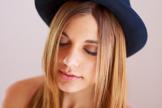 Woman, eyes closed and hat for fashion in studio with mock up for style on white background. Swedish model, hairstyle and confidence by satisfaction on face with vintage, clothes and fedora in space